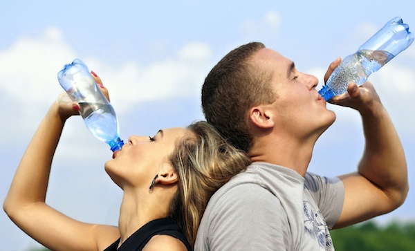 Man and woman drinking water after workout