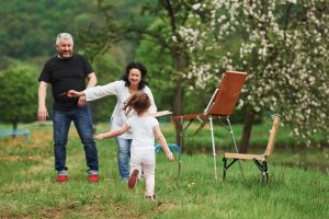 Grandmother and grandfather have fun outdoors with granddaughter