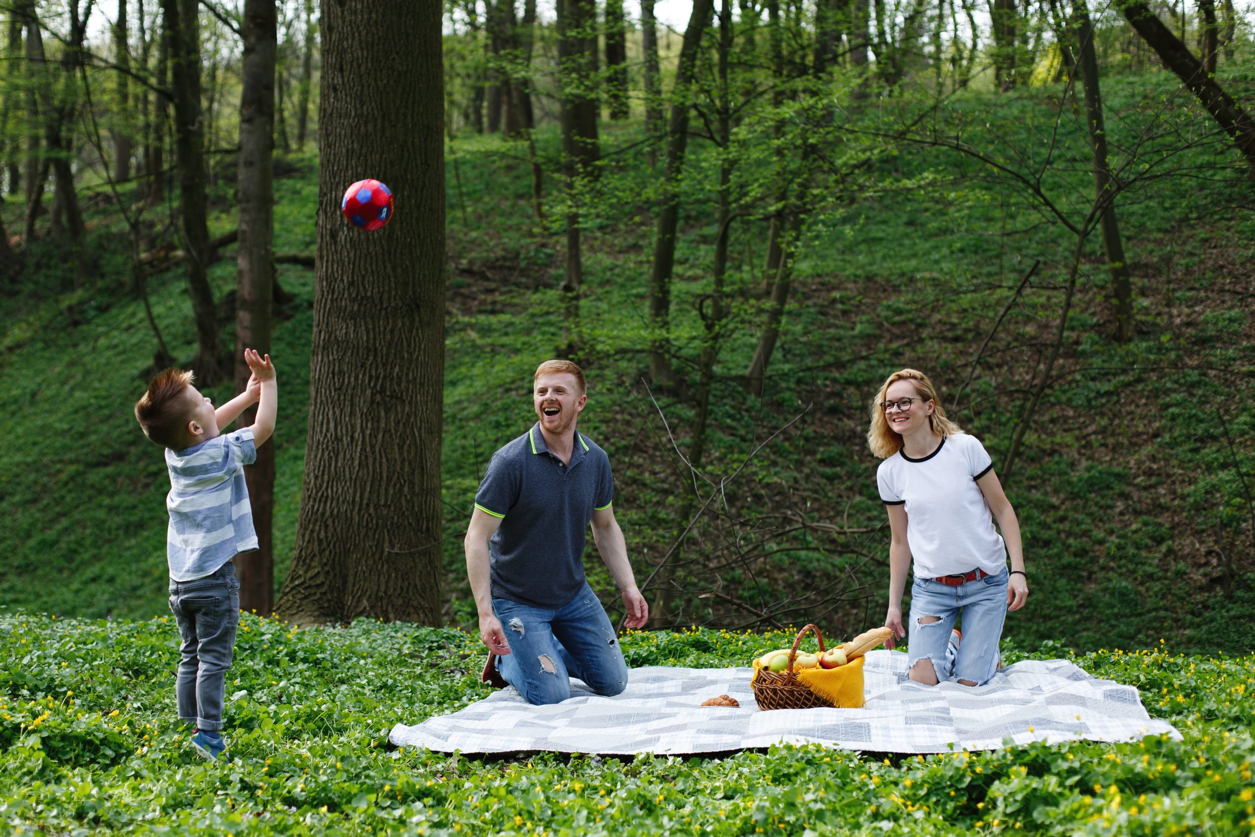 happy young family plays with ball plaid picnic park