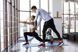 Man helping woman with her training 