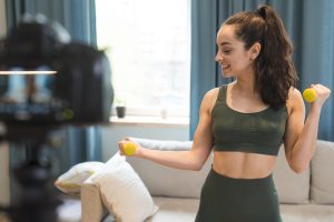 Sporty blogger using dumbbells