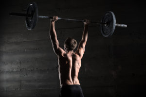 Man performing overhead barbell press exercise